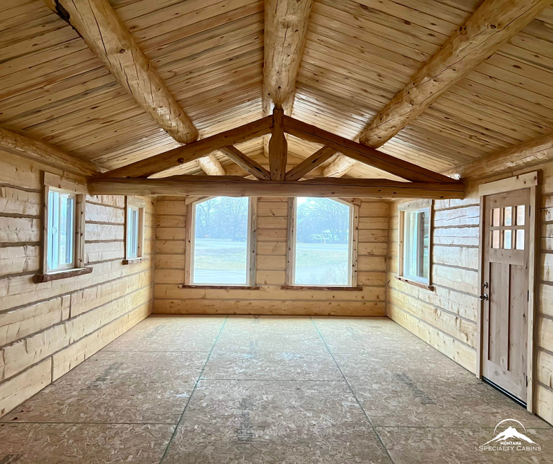 Open living space with exposed log truss and natural light