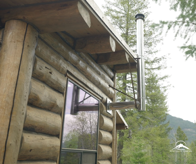 Stainless chimney and solid log walls built for mountain weather.