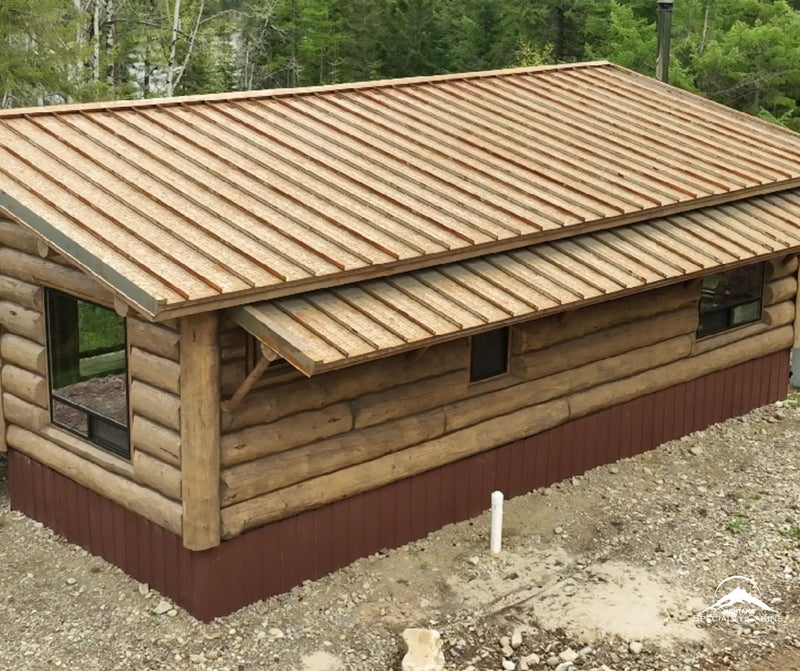 The back of the cabin shows solid log craftsmanship from every angle.