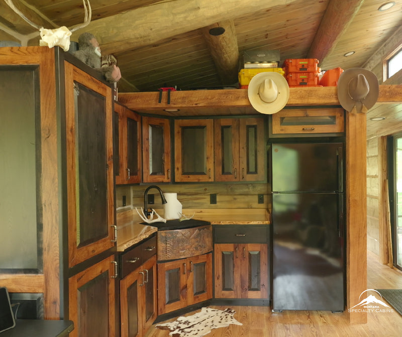 Custom rustic cabinetry with live-edge counters and a full-size fridge.